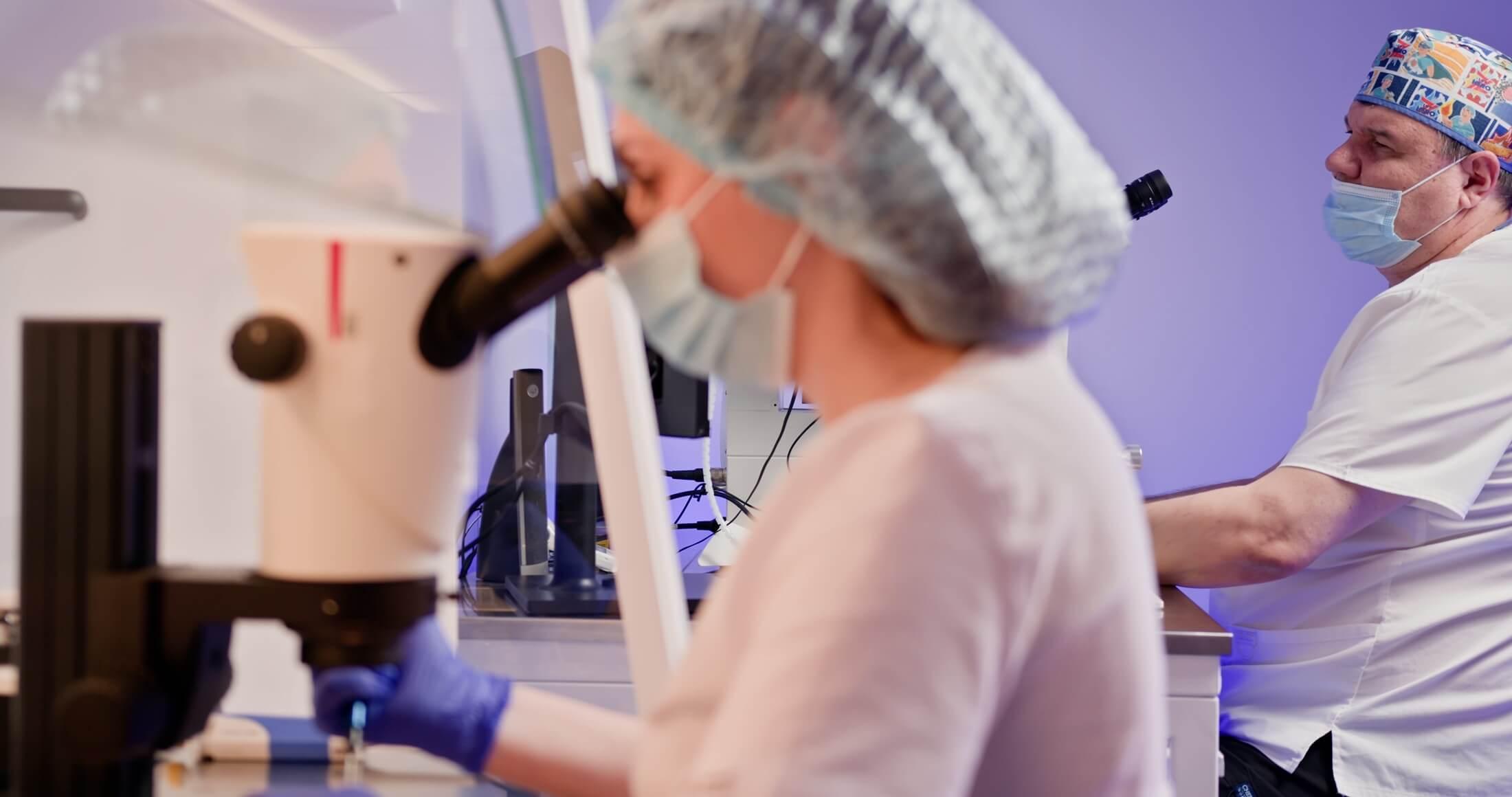 Lab Techs using a microscope